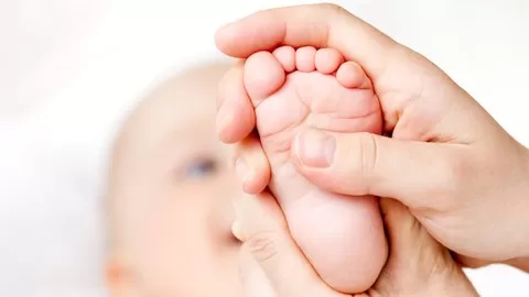 Bonding with children through gentle foot reflexology massage to stay healthy and happy